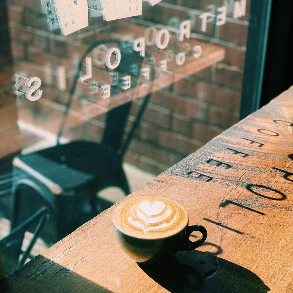 A latte on a sunlit cafe table