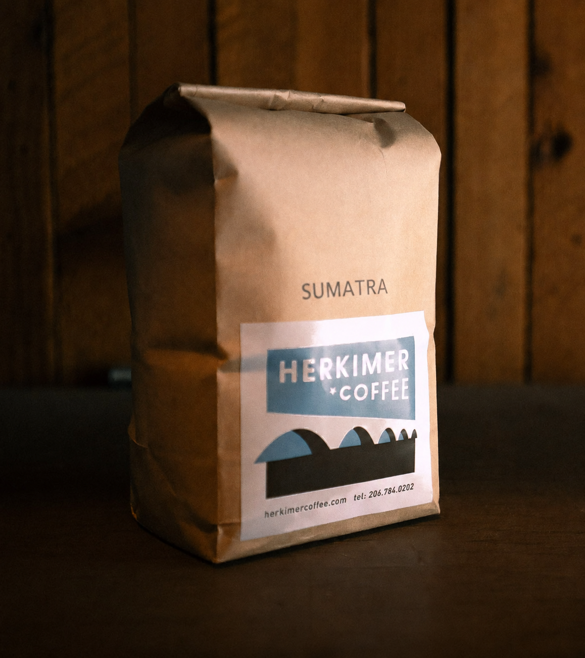 Sumatra whole bean coffee by Herkimer Coffee on a wooden background